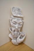 An unusual cast-plaster bust of a Chinese gentleman with tea bowl in hand, suspension loop to