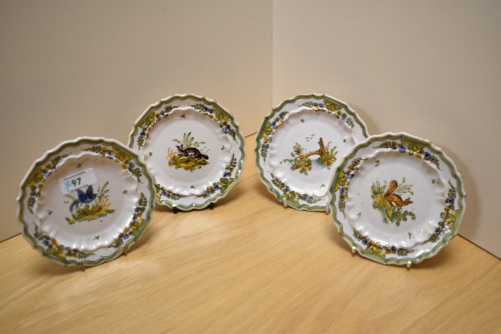 Four French Quimper ware style saucers, hand decorated with scenes from nature, diameter 14cm