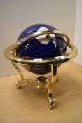 An enamelled terrestrial globe displayed within a brass gimballed frame, measuring 36cm tall