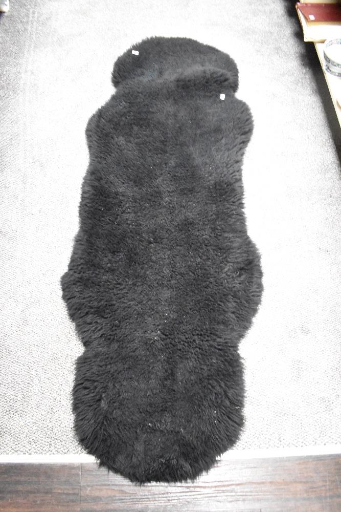 A double sized black sheep skin rug 180cm x 67cm sold along with a large sheep skin fleece cushion - Image 2 of 2