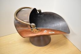 A cooper and brass coal scuttle, of traditional design with swing over-handle and conical foot