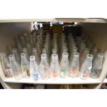 A collection of approximately fifty vintage dairy advertising milk bottles, various to include R.