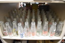 A collection of approximately fifty vintage dairy advertising milk bottles, various to include R.