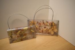 Two decorative laminated clear plastic hand bags, autumn foliage encapsulated within the laminate,