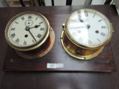 Two Bulk Head Clocks, one named Schatz, both mounted on wooden plinth