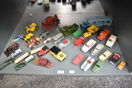 A shelf of playworn Dinky die-casts including Car Transporter, Bull Dozer, BMW 2000 Tilux battery
