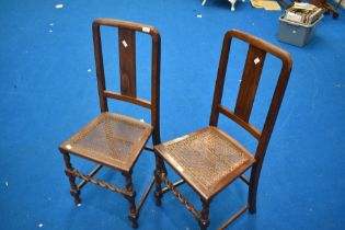A pair of early 20th Century cane seated bedroom chairs having oak twist frames