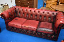 A red leather three seater button back chesterfield settee