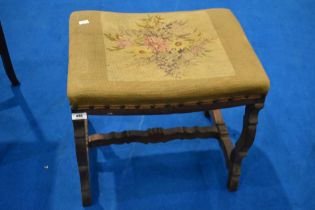 An Arts and Crafts oak stool having woolwork seat and shaped frame, width approx. 51cm