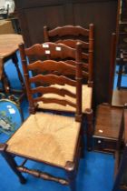 A pair of traditional ladder back chairs having rush seats