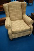 A modern wing back armchair in brown check upholstery , very clean condition