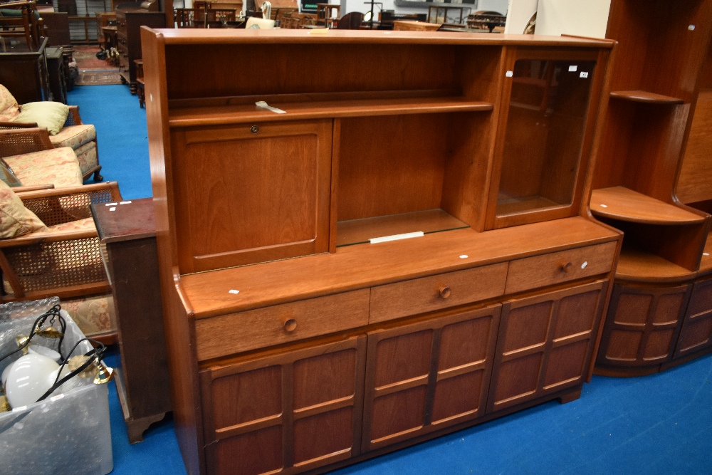 A vintage teak sideboard/dresser by Nathan, having cocktail and display section over triple frieze