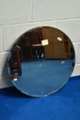 A vintage frameless wall mirror of circular form with peach tint, diameter approx. 61cm