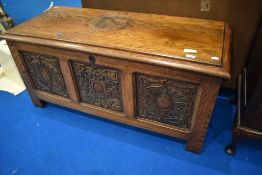 A heavy oak bedding chest having three carved panels, dimensions approx. W122 H58 D53cm
