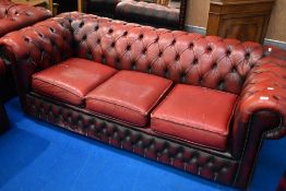 A red leather three seater button back chesterfield settee