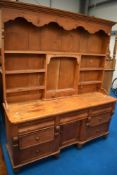 A Victorian and later pine dresser , having cupboard base and open delft rack, approx dimensions