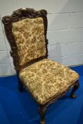 A 19th Century nursing chair having carved oak foliate and mythical frame with later upholstery,