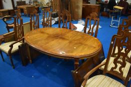 A reproduction Continental style extending dinining table and set of eight (six plus two) dining