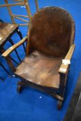 An early 20th Century savanorola style armchair with leather seat and back , lion shield motif to