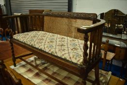 An early 20th Century oak twist frame salon settee have canework back, approx dimensions W106 H72