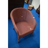 A vintage Lloyd Loom tub chair in pink