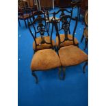 A set of four Victorian mahogany salon/dining chairs having shaped backs and upholstered seats