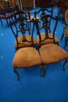 A set of four Victorian mahogany salon/dining chairs having shaped backs and upholstered seats