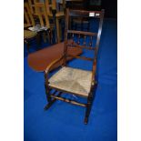 A traditional spindle back rocking chair having rush seat