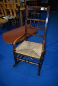 A traditional spindle back rocking chair having rush seat