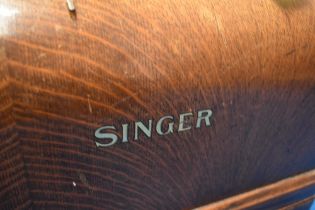 A vintage Singer sewing machine in oak case