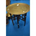 An Anglo Indian style brass top folding table of typical design, diameter approx. 58cm