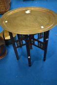 An Anglo Indian style brass top folding table of typical design, diameter approx. 58cm