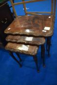 A nest of three period style tables with glass top and shaped legs