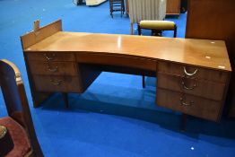 A vintage teak dressing table of curved form, width approx. 163cm, mirrors have been removed but are