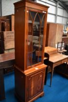 A reproduction yew wood narrow display unit, height approx. 190cm, width 56cm