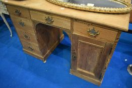 A stripped pine kneehole desk in the Victorian style