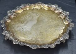 A Victorian silver salver of circular form with gadrooned rim and ornamental shell and scroll