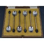 A cased set of six early 20th century silver coffee spoons, each with a black 'coffee bean' at the