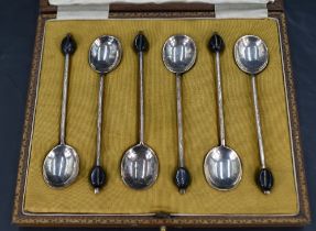 A cased set of six early 20th century silver coffee spoons, each with a black 'coffee bean' at the
