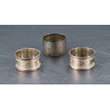 A pair of cased George V silver napkin rings, bright-cut with bands of guilloche decoration and