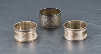 A pair of cased George V silver napkin rings, bright-cut with bands of guilloche decoration and