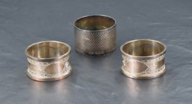 A pair of cased George V silver napkin rings, bright-cut with bands of guilloche decoration and