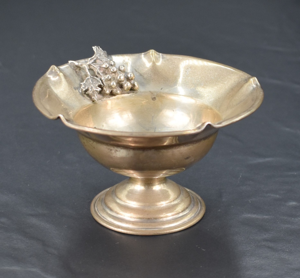 A small Continental white metal pedestal dish, having crimped and rolled rim, the booge ornamented