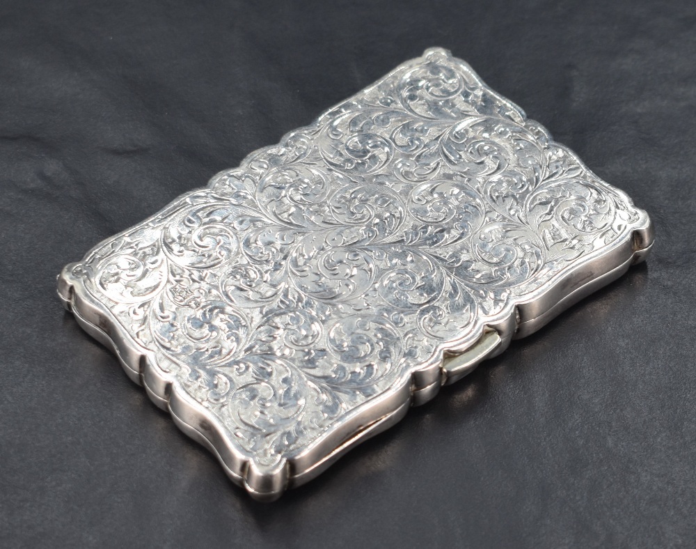 A late Victorian silver visiting card case, of shaped and hinged rectangular form with engraved
