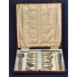 A cased set of eight silver plated coffee spoons with yellow coffee beans to the terminals with