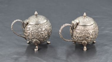 A pair of white metal (possibly colonial Indian) condiment pots, one slightly smaller and of