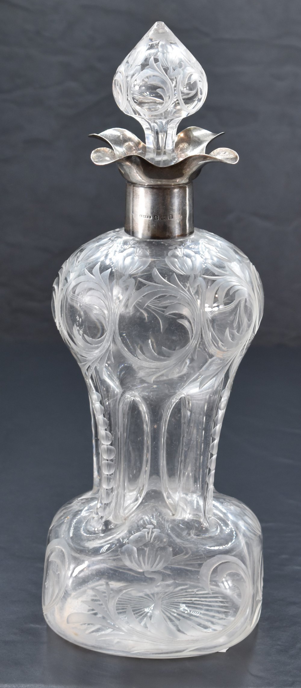 A George V silver mounted moulded and engraved glass 'Glug-Glug' decanter, having a foliate engraved