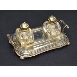 An early 20th century silver-plated inkstand, of shaped and step-moulded rectangular form with
