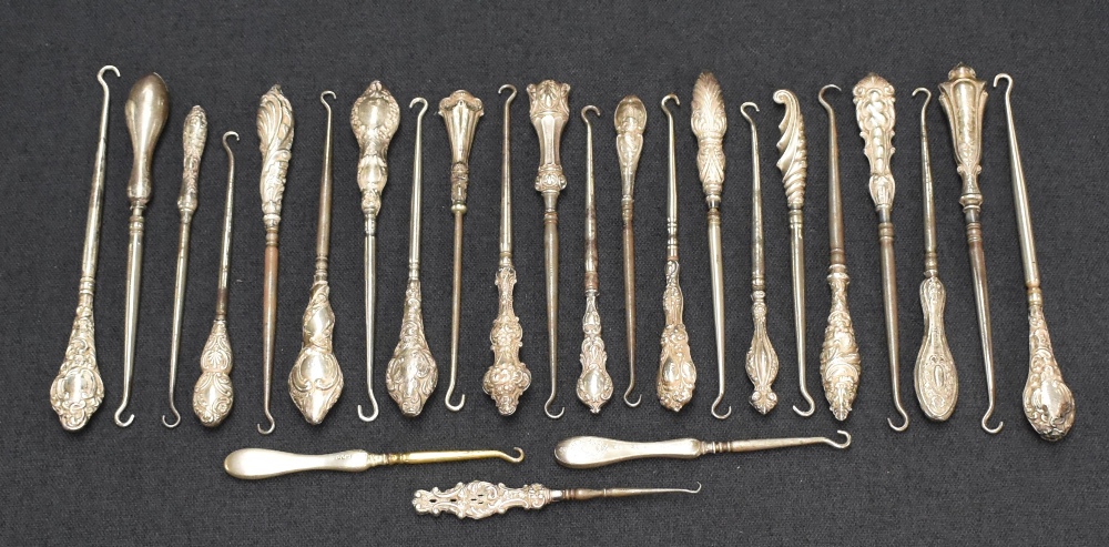 A collection of twenty-five silver handled button hooks, of various size and designs including