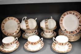 An assortment of breakfast cups and saucers and side plates, having white ground with dappled border